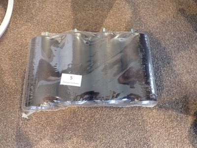 un sachet de piles posé par terre à côté d'une souris d'ordinateur