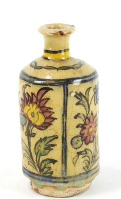 un vase jaune orné de fleurs, posé sur un fond blanc