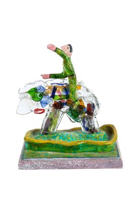 figurine of a man riding a horse on a green and yellow base