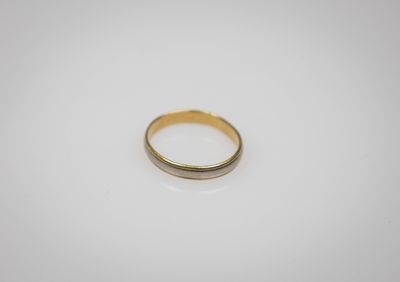 gros plan d'une bague en or sur une surface blanche