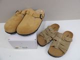 pair of tan sued clogs with buckles on top of a box