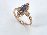 a close up of a gold ring with a blue stone
