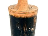 a vase that is sitting on a stand on a white surface