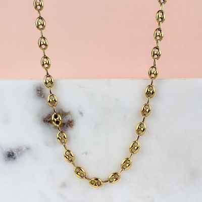 a close up of a gold chain necklace on a marble surface