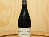une bouteille de vin posée sur un tonneau en bois