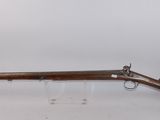 an old rifle on display in a glass case
