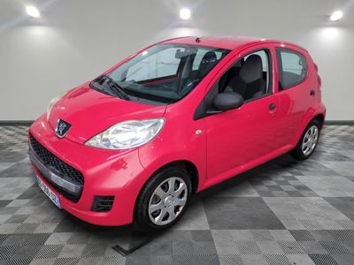une voiture rouge est garée dans une pièce au sol en damier