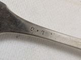 a silver spoon with the word t g on it