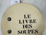 une affiche accrochée au mur sur laquelle on peut lire « Le Livre des soupes »