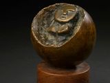 bronze sculpture of a snail shell on a wooden stand
