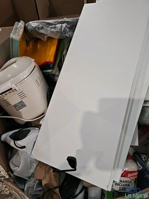 a white refrigerator in a cardboard box full of stuff