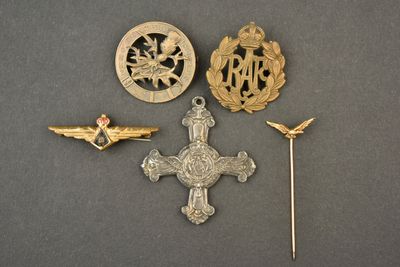 trois insignes et une épingle posés sur une surface grise
