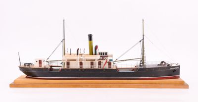 une petite maquette de bateau posée sur un socle en bois