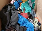 a cardboard box filled with clothes and clothing on the floor