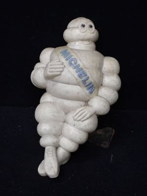 une petite statue représentant un homme avec une écharpe autour du cou