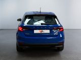 the rear end of a blue car in a white room