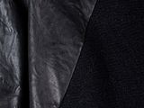 a close up of a black leather jacket with a black shirt underneath it