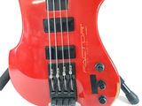 a red electric bass guitar sitting on top of a stand