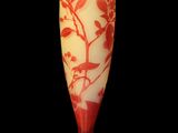 a red and white vase sitting on a black surface