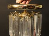 a person holding a glass chandelier in their hand