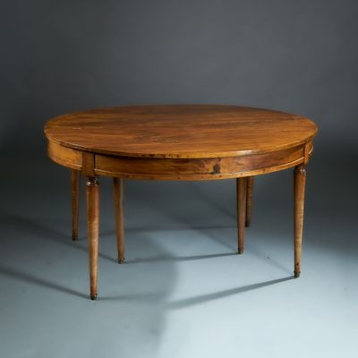 une table à manger ovale à deux pieds, avec un plateau en bois