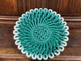 assiette décorative verte et blanche posée sur un meuble en bois