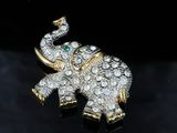 a close up of an elephant brooch with diamonds on a black surface