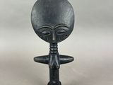 une figurine d'extraterrestre devant laquelle se trouve une bouteille de vin