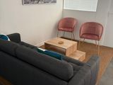 a living room with a couch, chair, coffee table, and television