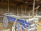 un chariot bleu garé à l'intérieur d'une grange aux murs en bois