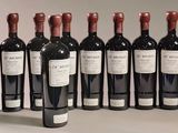 six bouteilles de vin sont alignées sur une table