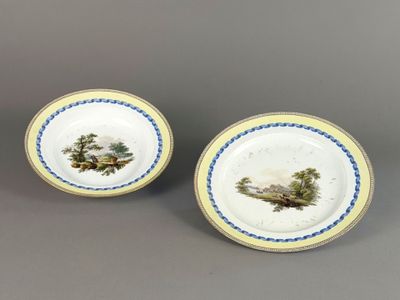 deux assiettes ornées d'un paysage, dont l'une est peinte en bleu et blanc