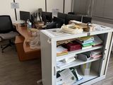 a desk with a bookcase and a computer monitor on it