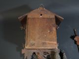 a wooden birdhouse with a bird on the top and a bird on the bottom