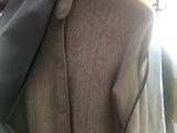 a person that is tying a tie on a jacket