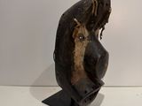 statue of a woman ' s head on a metal stand on a white surface