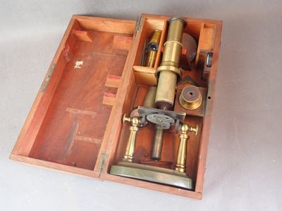 une boîte en bois contenant un microscope, posée sur une table