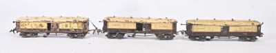 trois wagons miniatures sont alignés les uns à côté des autres sur une surface blanche
