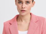 the woman is wearing a pink blazer and white top