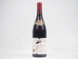 une bouteille de vin rouge posée sur une table blanche
