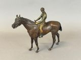a bronze statue of a jockey on a horse