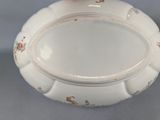 a white bowl with a red flower on top of it