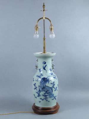 une lampe de table bleue et blanche avec un pied en laiton et un vase bleu et blanc orné d'un dragon