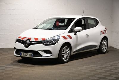 La voiture blanche est garée dans le garage dont le sol est en damier.