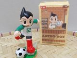 a figurine of a boy with a soccer ball on a table
