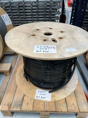 une bobine de fil noir posée sur une palette dans un entrepôt