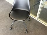 une chaise noire placée devant une fenêtre
