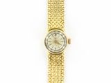 an image of a woman ' s wrist watch with a gold bracelet