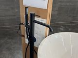une baignoire blanche placée à côté des toilettes dans une salle de bains