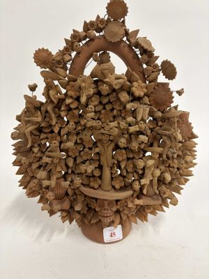 une sculpture en bois représentant un panier rempli de noix et de feuilles